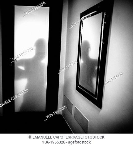 Dressing of the bride, shadow behind the bedroom door