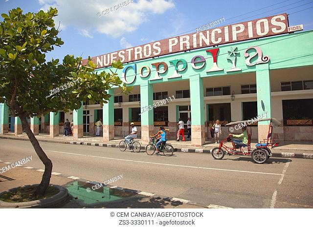 Cyclists in front of the buildings at the Paseo del Prado or so called Boulevard in the city center, Cienfuegos, Cuba, Central America