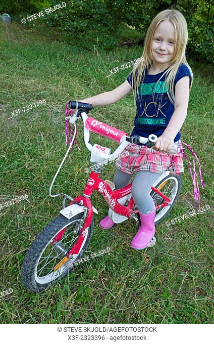 Young Polish girl age 6 on her decorated fancy bicycle. Zawady Central Poland