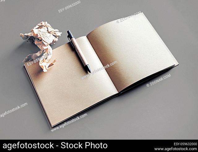 Open blank kraft paper book or sketchbook, pen and crumpled paper. Branding mock up. Copy space for text