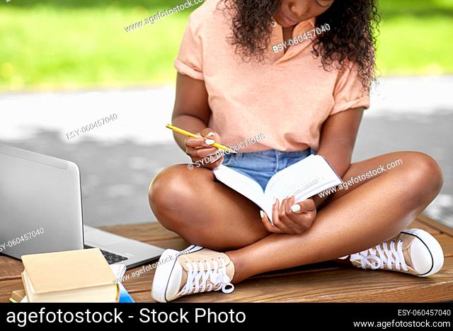 african american student girl making notes in book
