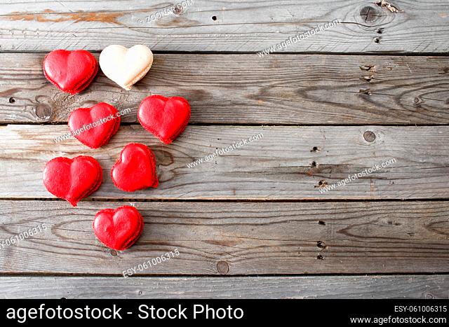 Red macaroons desserts on wooden background. dessert for breakfast on Valentine's Day