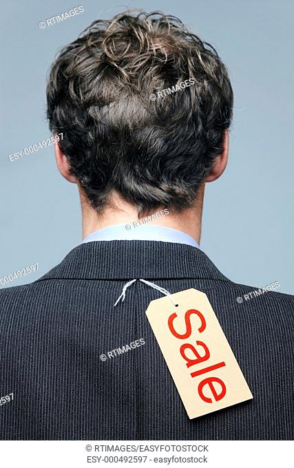 Rear view of a male wearing a suit jacket with a Sale label on it
