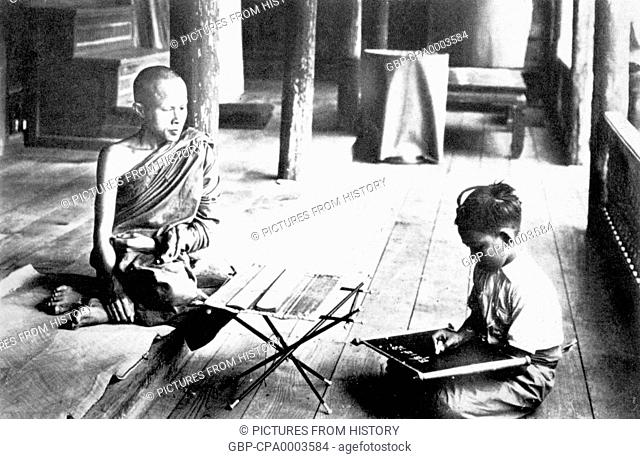 Thailand: A 1900 photograph of a Buddhist monk teaching a child in Nakhon Phanom in Isarn, northeastern Siam