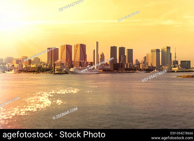 Beautiful sunset view from Rainbow Bridge of Hamamatsucho and Hinode coast in Tokyo Bay with the Symphony Cruise in front and Sky Tree in background