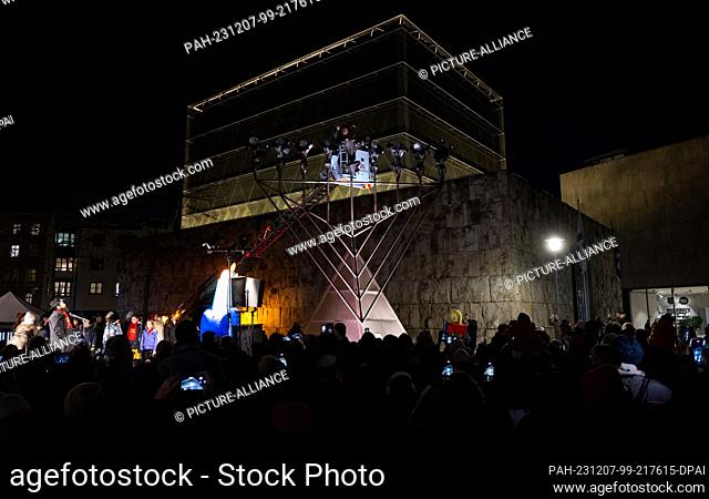 07 December 2023, Bavaria, Munich: Dieter Reiter (SPD), Lord Mayor of Munich, lights the first light on the Hanukkah candelabra in front of the main synagogue...
