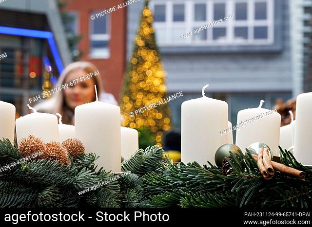24 November 2023, Lower Saxony, Osnabrück: Christmas decorations and candles can be seen outside a store. Numerous stores and online stores celebrate Black...