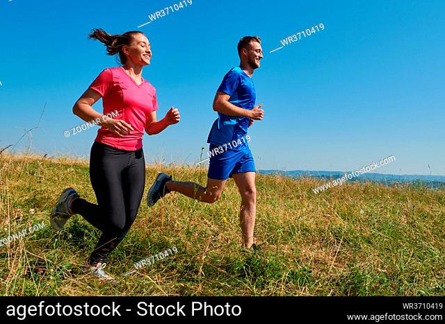 couple jogging in a healthy lifestyle on a fresh mountain air at beautiful sunny summer nature