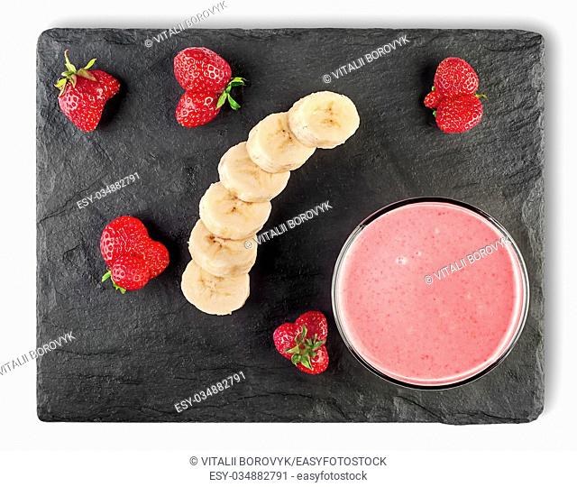 Banana strawberry smoothies with ingredients on black shale stone top view