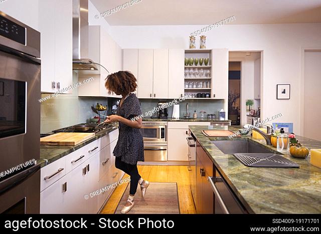 Female ballet dancer cooking in a residential kitchen