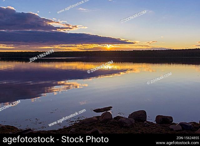 Evening on the White Sea. The sun shines through the clouds. Kandalaksha Gulf, Karelia, Russia, end of June