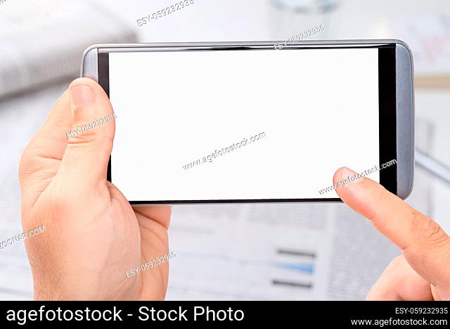 Smartphone with empty white display and Newspapers in the background