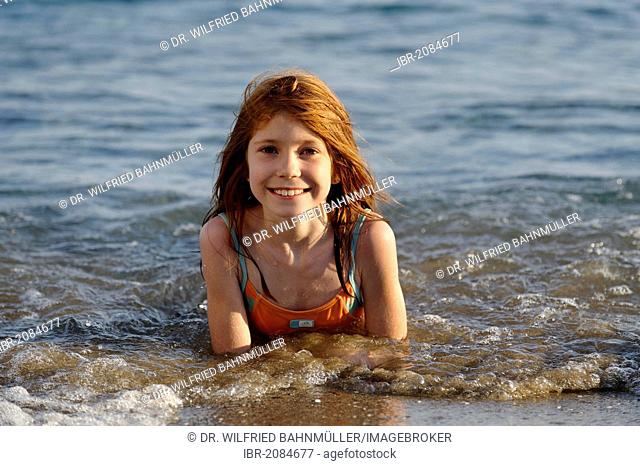 Smiling girl lying in the sea