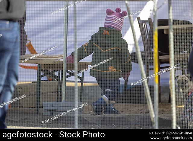 19 March 2022, Slovakia, Vysne Nemecke: A little girl runs in a cordoned-off pick-up area after escaping across the border to Slovakia with her mother