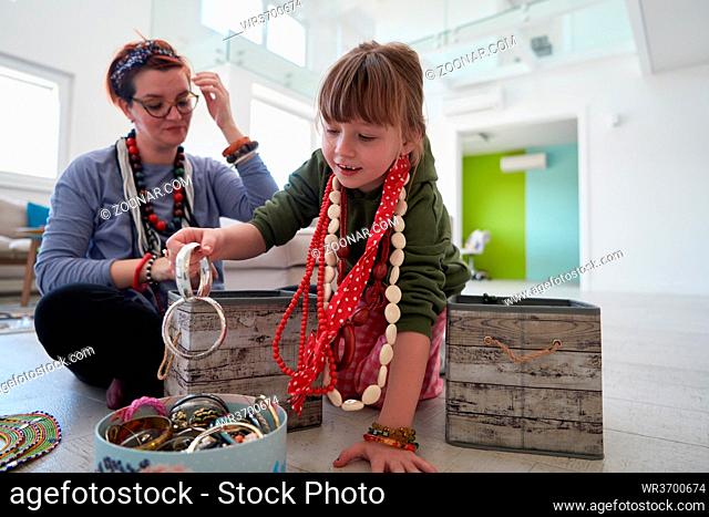 Mother and little girl daughter playing with jewelry while staying at home in coronavirus quarantine