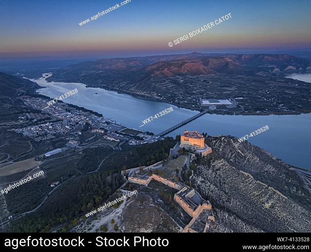 Aerial view of the castle of Mequinenza at the confluence of the Segre and Ebro rivers in a winter sunset (Bajo Cinca, Zaragoza, Aragon, Spain)