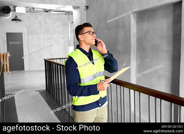 male supervisor with clipboard calling on phone