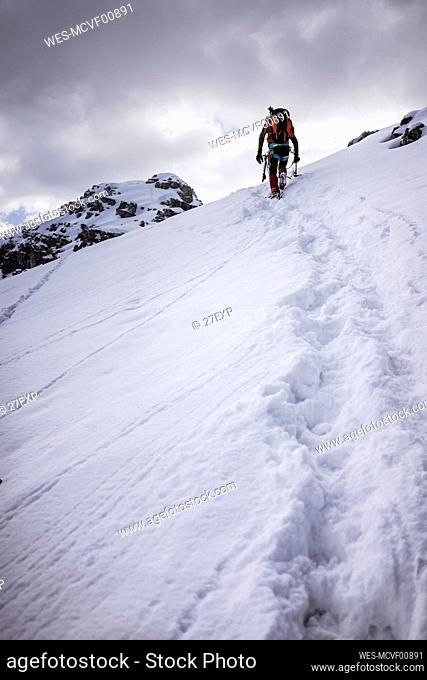 Male hiker on snow covered mountain in Orobie Alps, Lecco, Italy