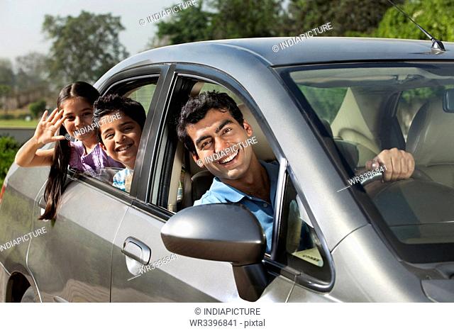 Portrait of father and kids in a car