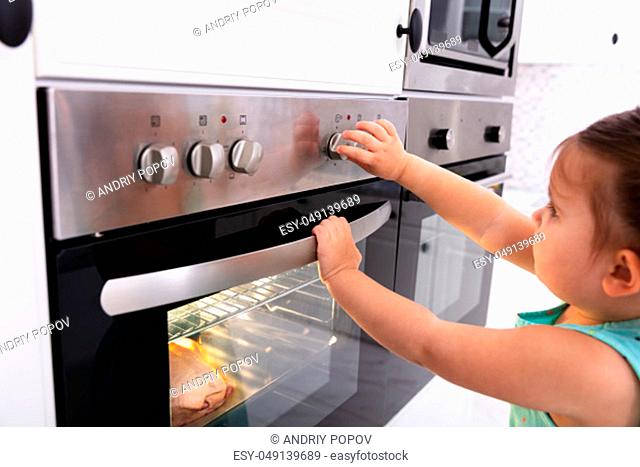 Close-up Of A Pretty Girl Adjusting Temperature Of Microwave Oven