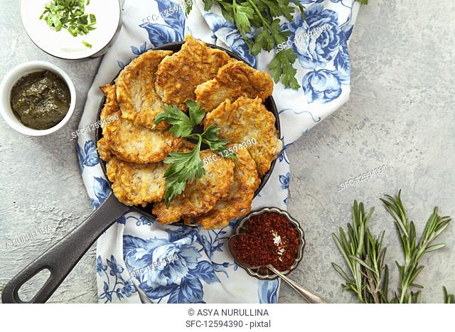 Jewish potato latkes with sour cream, parsley, dry red pepper flakes and mint sauce