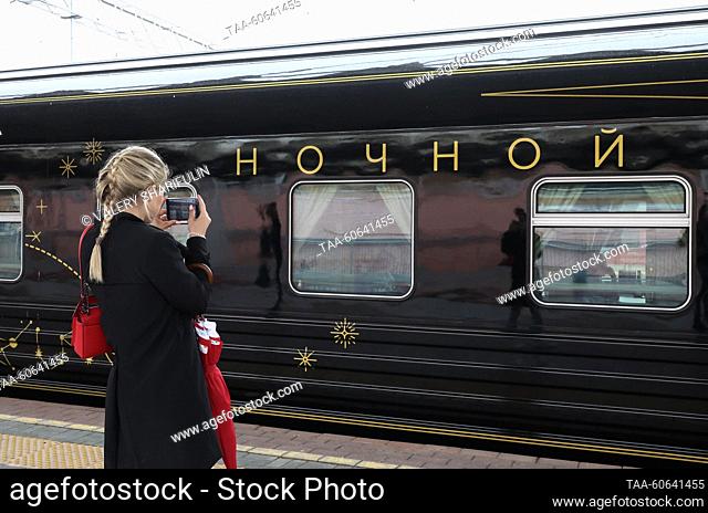 RUSSIA, MOSCOW - JULY 24, 2023: A girl takes pictures of a Night Express train running between St Petersburg and Moscow, at Leningradsky railway station