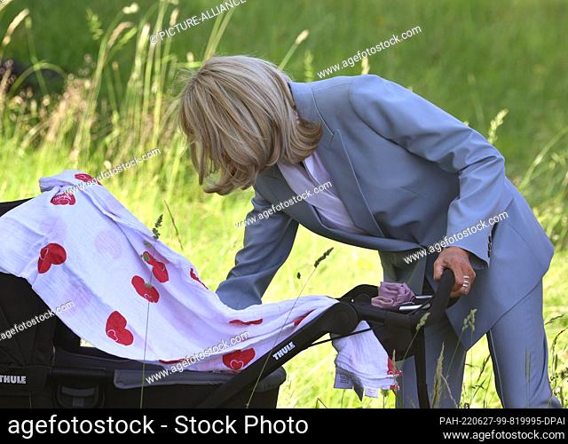 27 June 2022, Bavaria, Elmau: Brigitte Macron, wife of French President Emmanuel Macron, stands in front of a baby carriage containing the baby of former...