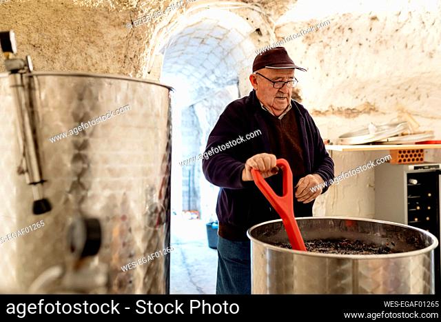 Senior male winemaker preparing wine at winery