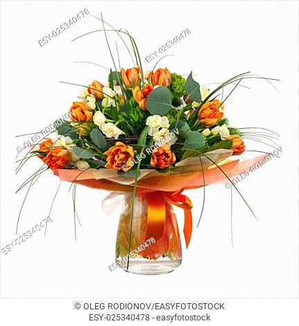 Bouquet of narcissus, tulips and other flowers in glass vase isolated on white background. Closeup