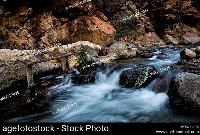 Water flowing in a river through a rocky mountain slope creating small waterfalls at Troodos mountains, Cyprus