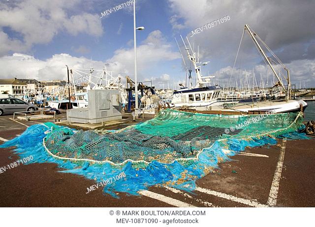 Fishing nets and trawlers on quayside. Quineville harbour Normandy France