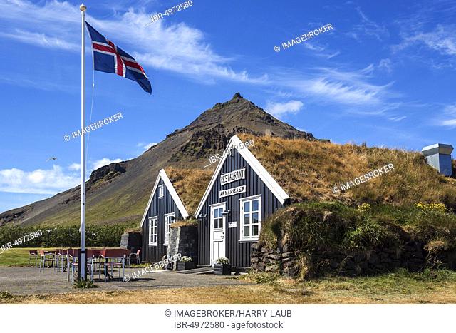 Wooden houses, restaurant Arnarbaer, Icelandic flag, behind the mountain Stapafell, Arnarstapi, peninsula Snæfellsness, Iceland, Europe