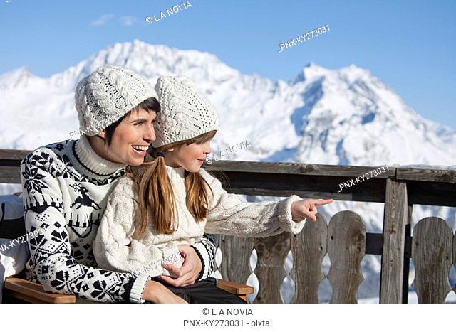 Mother and daughter on balcony at ski resort