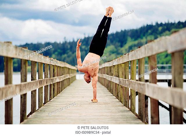Man doing hand stand on one hand, Seattle, Washington, United States, North America
