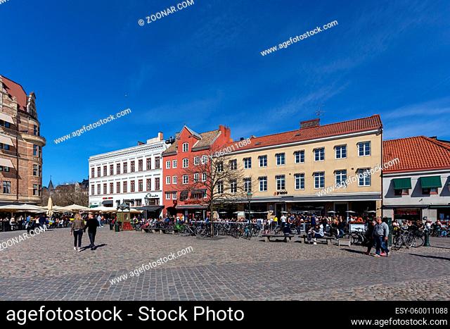 Malmo, Sweden, April 20, 2019: Historic buildings and people in cafes and restaurants on the Little Square