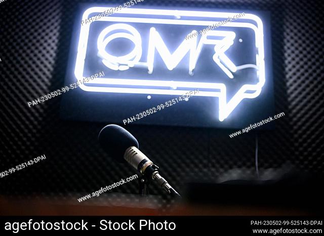 PRODUCTION - 17 April 2023, Hamburg: A podcast microphone stands in a recording studio in front of the OMR company logo. When the team from Hamburg-based media...