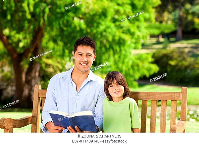Son with his father reading a book
