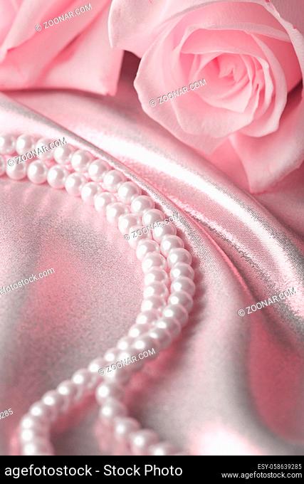 Pearl beads and cream rose on the silk background. Tenderness design