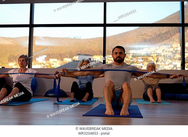 Trainer and group of senior women performing yoga