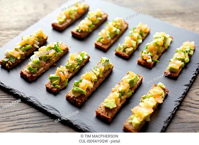 Guacamole, smoked salmon and rye bread canapes