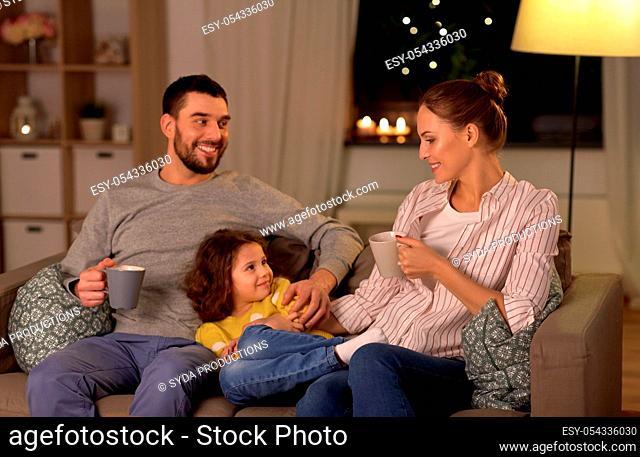 portrait of happy family sitting on sofa at home