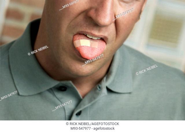 Caucasion man with bandage on tongue; face partially visible. Soft green casual shirt