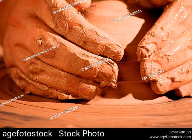Hands forming clay