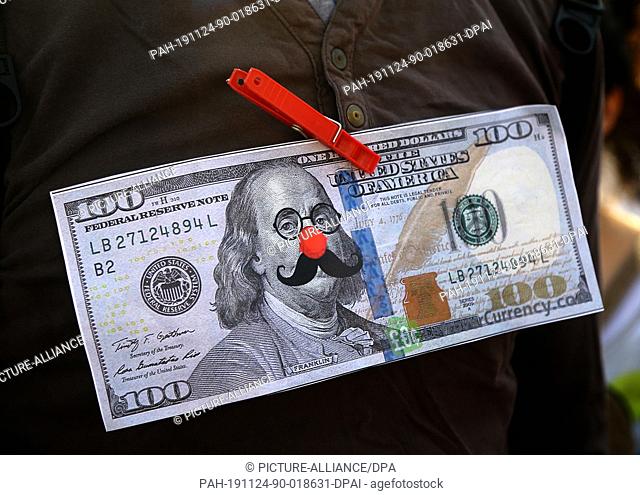 24 November 2019, Lebanon, Aaoukar: A Lebanese protester buckles a mock version of the US dollar to his chest during an anti-US government demonstration against...