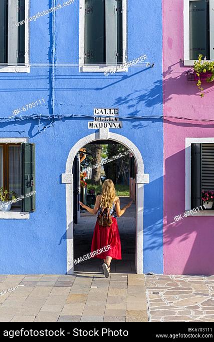 Young woman in front of colorful houses, colorful house facades, Burano Island, Venice, Veneto, Italy, Europe