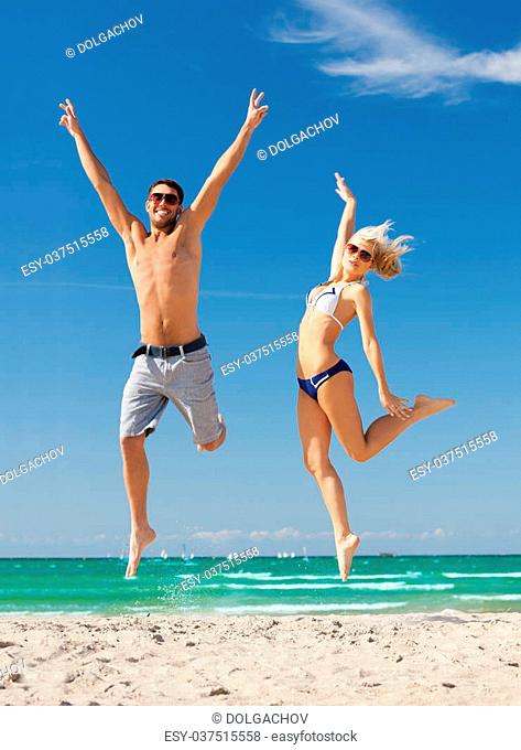 picture of happy couple jumping on the beach