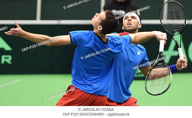Adam Pavlasek, left, returns a ball as his partner Jiri Vesely, right, looks on during their Davis Cup World Group first round doubles tennis match against...