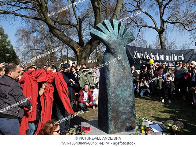 08 April 2018, Germany, Berlin: People unveiling the memorial for Burak.B. The young man was shot in a street in Neukoelln on 05 April 2012