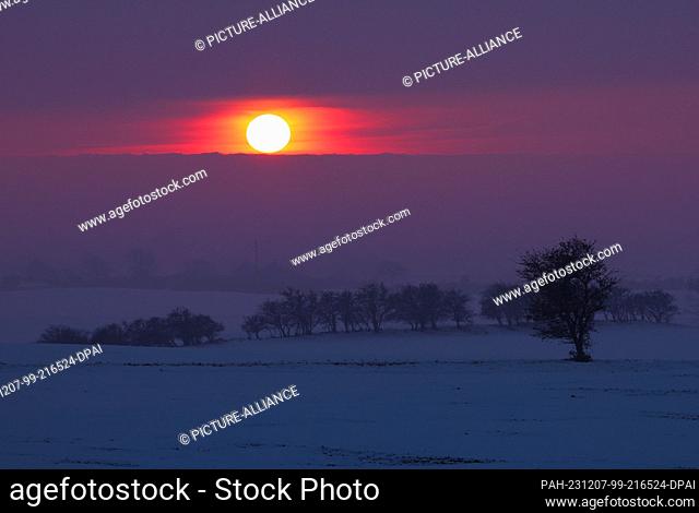 07 December 2023, Schleswig-Holstein, Lütjenbrode: The sun sets over snow-covered fields on Fehmarnsund. Photo: Christian Charisius/dpa
