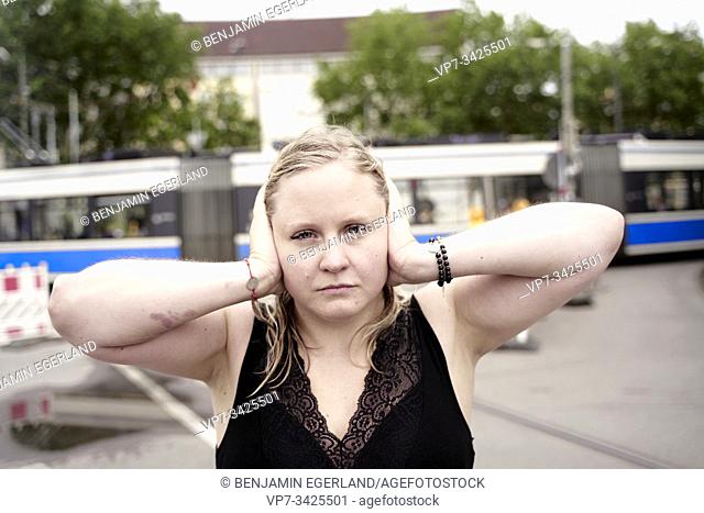 Woman covering ears, Munich, Germany